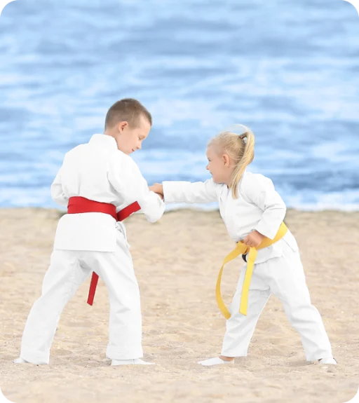 2 kids with red and yellow belts sparring.