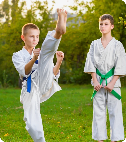 2 young boys with blue and green belts.